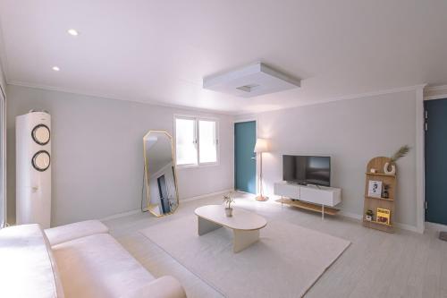 a white living room with a white couch and a table at 인천 간석동 머니스테이 in Incheon