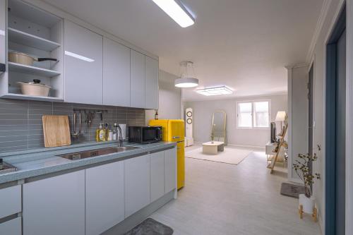 a kitchen with white cabinets and a yellow refrigerator at 인천 간석동 머니스테이 in Incheon