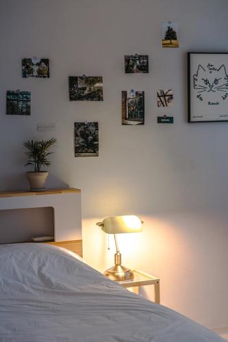 a bedroom with a bed and a lamp and pictures on the wall at 인천 간석동 머니스테이 in Incheon