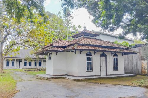 a small white building with a tiled roof at RedDoorz at Hotel Padjajaran Tasikmalaya in Tasikmalaya