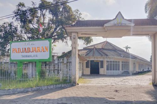 a sign in front of a building with a gate at RedDoorz at Hotel Padjajaran Tasikmalaya in Tasikmalaya