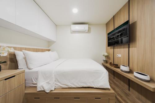 a bedroom with a bed and a tv on a wall at Verdant Bali Tirta Lepang in Ketewel