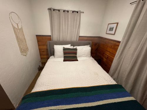a small bedroom with a bed with a curtain at Three Pines Cabins in Big Bear Lake