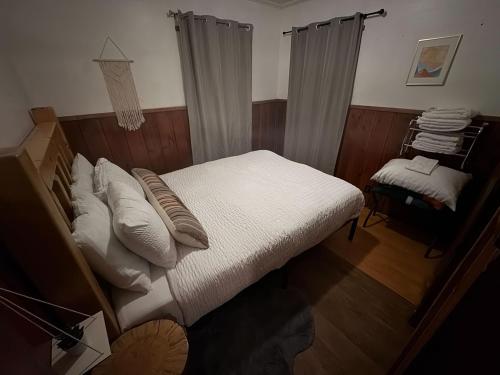a bedroom with a bed with white sheets and pillows at Three Pines Cabins in Big Bear Lake
