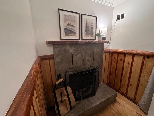 a fireplace in a living room with two pictures on the wall at Three Pines Cabins in Big Bear Lake