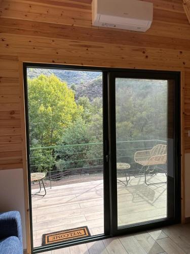 a sliding glass door to a deck with a patio at Cozy Glamping Cabin With Pool, Perfect For Couples & Families in Arakapas