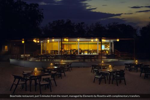 a restaurant with tables and chairs at night at Elements by Rosetta- Varca, Goa in Varca