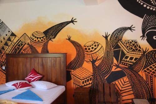 a bedroom with a bed with a mural on the wall at Dreamvillage in Dodanduwa