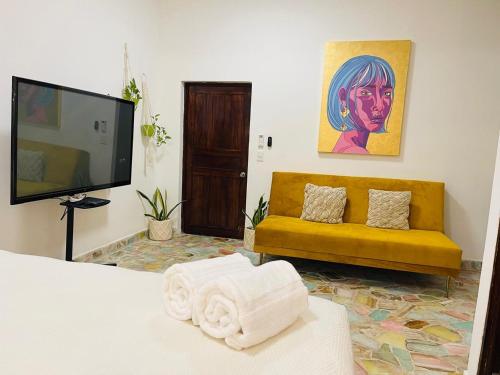 a living room with a yellow couch and a television at Private Room in a Boho House N1 in Puerto Vallarta