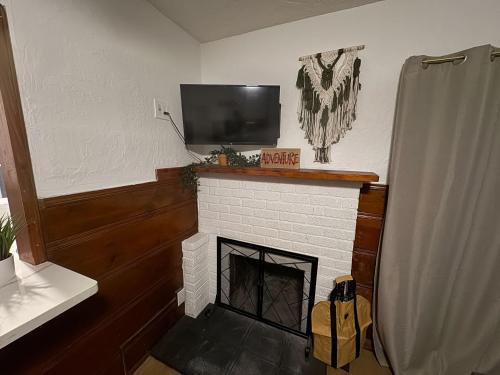 a living room with a fireplace with a flat screen tv at Three Pines Cabins in Big Bear Lake