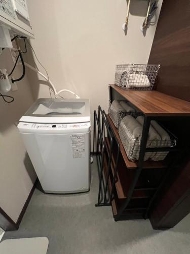 a laundry room with a washing machine and a table at Go Home 豪 in Furano