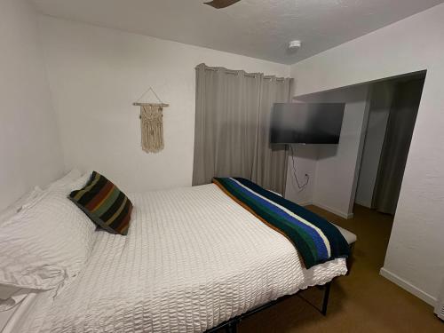 a bedroom with a bed and a flat screen tv at Three Pines Cabins in Big Bear Lake