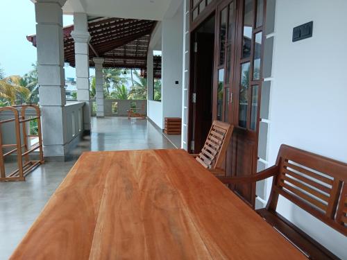 a wooden table in the middle of a house at Plantation Surf Inn & Restaurant - Midigama in Midigama