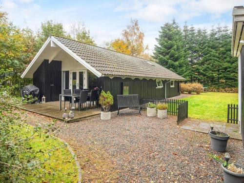 a small house with a patio and a table at 6 person holiday home in Ansager-By Traum in Ansager