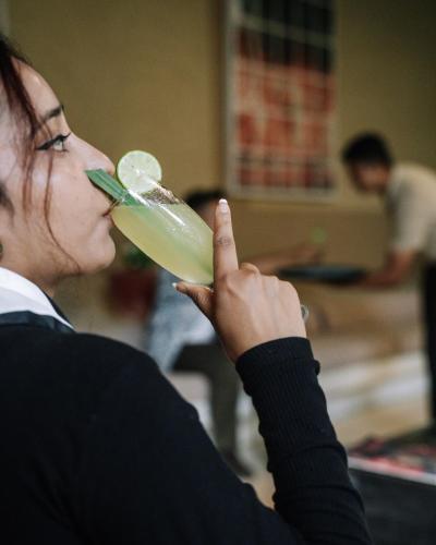 a woman drinking a drink with a lime at Kasara Chitwan in Chitwan