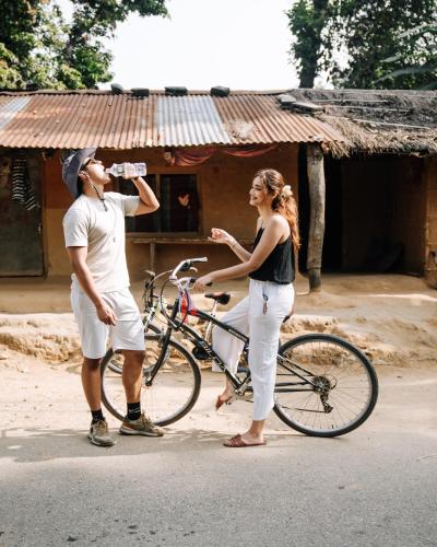 a man and a woman standing next to a bike at Kasara Chitwan in Chitwan