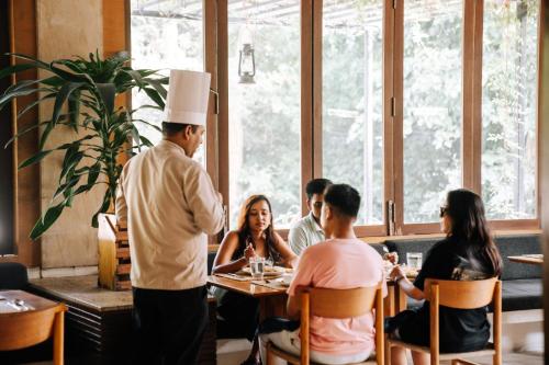 a group of people sitting at a table in a restaurant at Kasara Chitwan in Chitwan