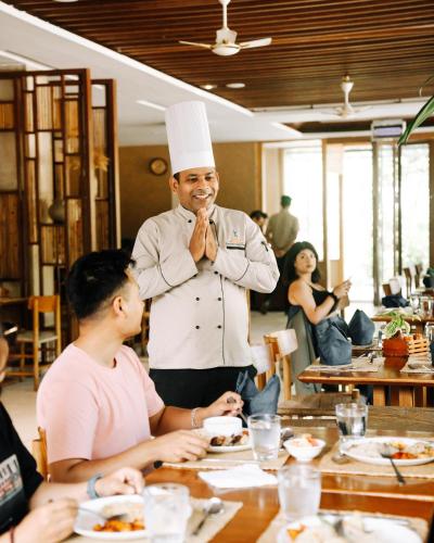 a man wearing a chef hat standing in a restaurant at Kasara Chitwan in Chitwan