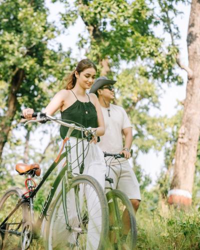 a man and a woman standing next to a bike at Kasara Chitwan in Chitwan