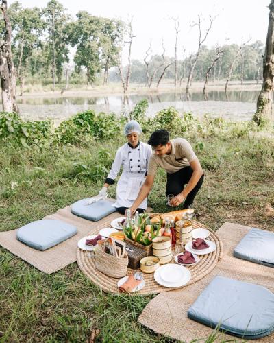 two people preparing food on a picnic blanket at Kasara Chitwan in Chitwan