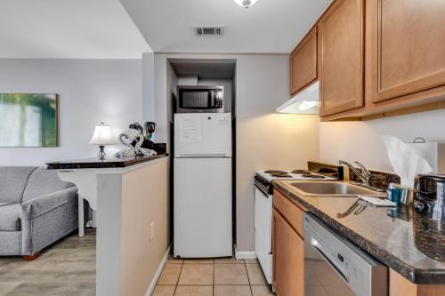 a kitchen with a white refrigerator and a sink at Oceanfront Condo at Meridian Plaza in Myrtle Beach