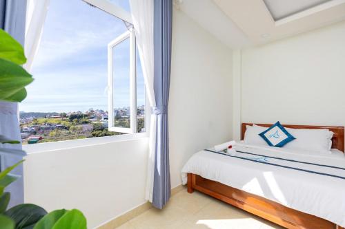 una camera da letto con un letto e una grande finestra di Villa đà lạt - happy family house a Da Lat