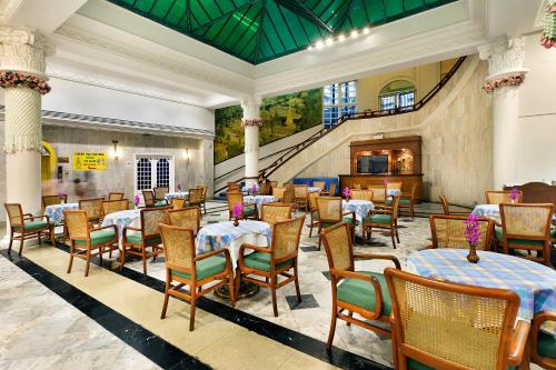 a restaurant with tables and chairs and a staircase at Royal Rattanakosin Hotel SHA Plus in Bangkok