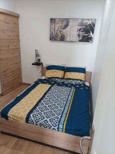une chambre avec un lit avec une couette bleue et jaune dans l'établissement T2 viel Antibes hyper centre, à Antibes
