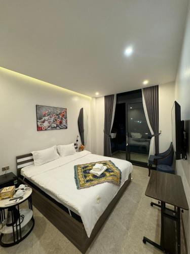 a hotel room with a bed and a television at Liverpool House Mộc Châu in Mộc Châu