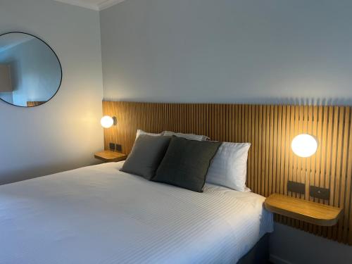 a bedroom with a large bed and a mirror at South Seas Motel in Merimbula