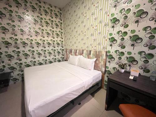 GlugurにあるLouise Hotelのベッドルーム1室(ベッド1台、皿の壁付)