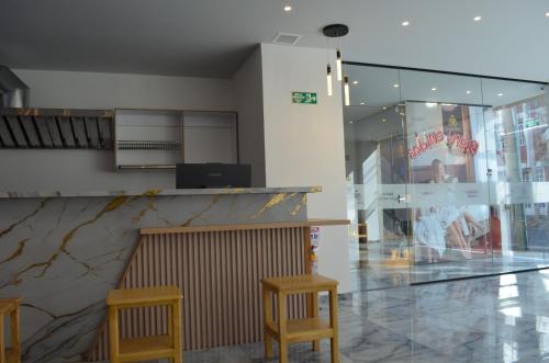 a restaurant with two stools and a counter and two chairs at Hotel Diamond Luxury Tunja in Tunja