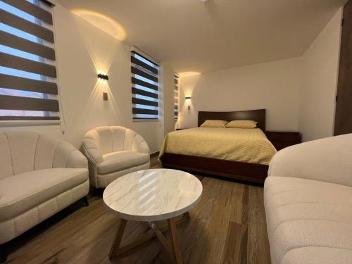 a bedroom with a bed and a couch and a table at Hotel Diamond Luxury Tunja in Tunja