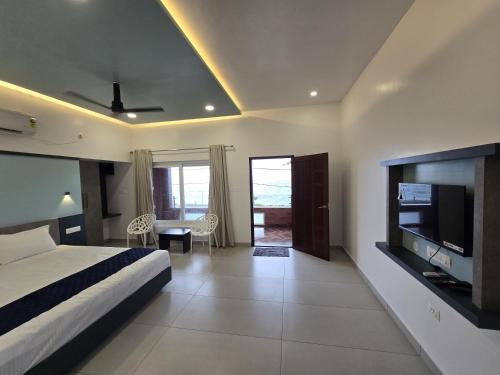 a bedroom with a bed and a television in a room at Sea Breeze Cherai Homestay in Pallipuram