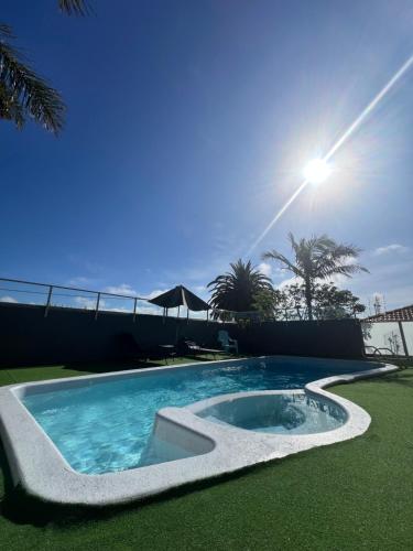 a swimming pool in the grass with the sun in the background at Narooma Palms Holiday Apartments in Narooma