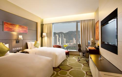 a hotel room with two beds and a flat screen tv at Crowne Plaza Hong Kong Causeway Bay by IHG in Hong Kong