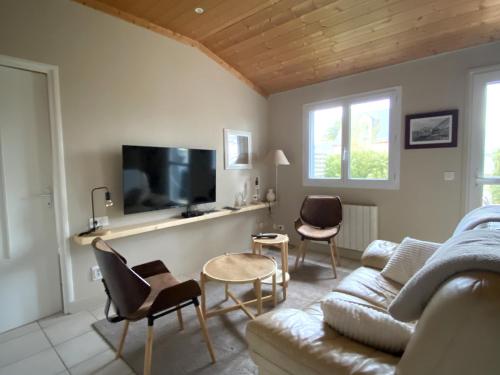 un salon avec un canapé, des chaises et une télévision dans l'établissement Charmant T2 RDC avec jardin privatif à 500m de Loctudy - FR-1-813-1, à Groix