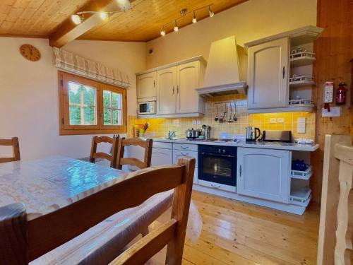 une cuisine avec des armoires blanches et un plancher en bois dans l'établissement Appartement duplex cosy avec parking à Morillon, 6 couchages - FR-1-624-175, à Morillon