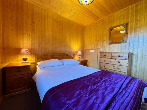 une chambre avec un grand lit et des murs en bois dans l'établissement Appartement duplex cosy avec parking à Morillon, 6 couchages - FR-1-624-175, à Morillon