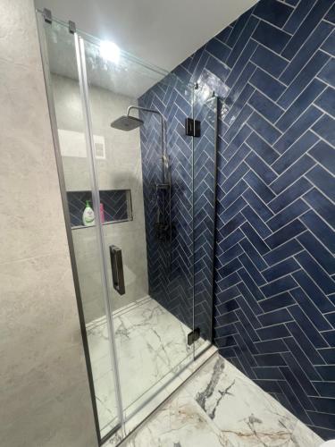 a bathroom with a shower with blue tiles at Private Room in Kawakawa