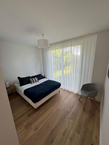 une chambre blanche avec un lit et une fenêtre dans l'établissement Charmante maison de standing 1 km des plages, à Larmor-Plage