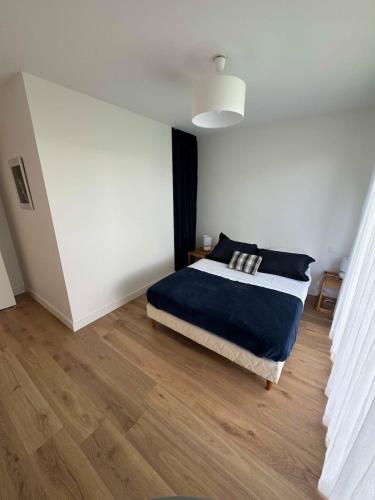 une chambre avec un lit et un mur blanc dans l'établissement Charmante maison de standing 1 km des plages, à Larmor-Plage