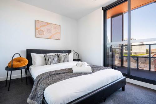 Modern 2B Apt with Views Near Swinburne University في ملبورن: غرفة نوم بها سرير ونافذة كبيرة