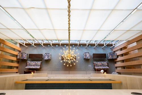a dining room with a chandelier hanging from the ceiling at KKR Hotel Kanazawa in Kanazawa