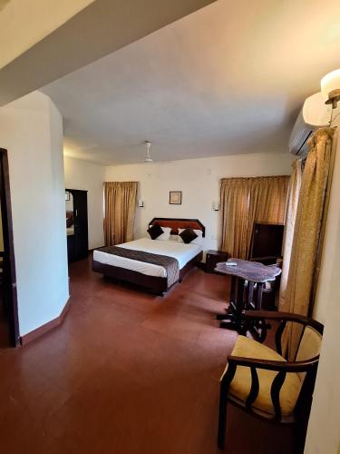 a bedroom with a bed and a table in it at Mangotree Kochi in Cochin