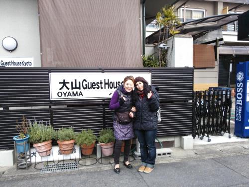 two women posing for a picture in front of a building at Oyama Guesthouse Kyoto in Kyoto