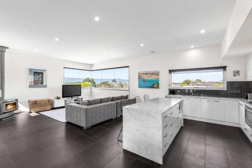a kitchen and living room with a couch and a tv at Stylish getaway near beach with stunning sunsets in Saint Leonards
