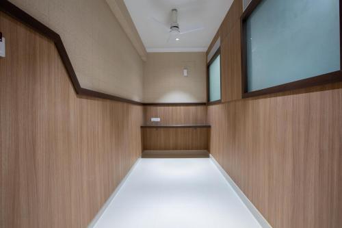 an empty room with wood paneling and a large window at Hotel PRM Aruna Archadia in Erode