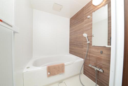 um banheiro com banheira e pia em 和ノ楓cottage第三 新宿の2階建て4室2シャワー2トイレ em Tóquio