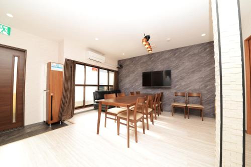 a dining room with a table and chairs and a tv at 和ノ楓cottage第三 新宿の2階建て4室2シャワー2トイレ in Tokyo